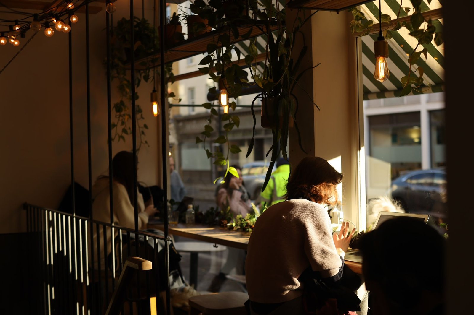 Coin de café cosy avec plantes et lumière naturelle.