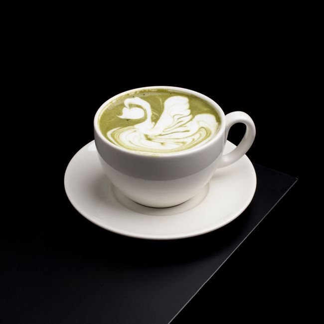 Matcha latté avec dessin dans la mousse, teinte rosée.